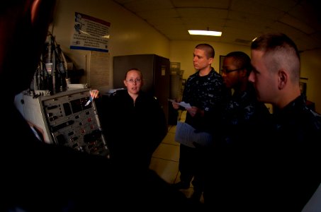 US Navy 100125-N-4482V-012 ire Controlman 1st Class Raenna Roberts, left, explains the Phalanx Close-in Weapons System (CIWS) to Sailors