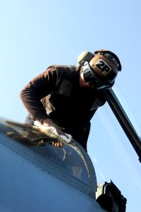 US Navy 100123-N-3038W-052 Sailor cleans canopy of a F-A-18E Super Hornet aboard USS Nimitz photo