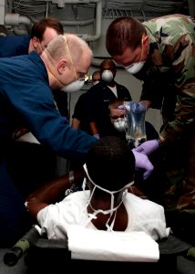 US Navy 100123-N-5712P-026 Sailors and Marines aboard the amphibious assault ship USS Nassau (LHA 4) assist patients being evacuated from Haiti during humanitarian aid efforts photo