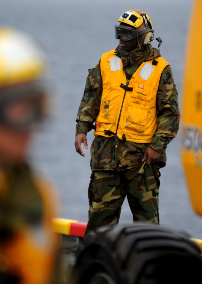 US Navy 100125-N-5215E-020 viation Boatswain's Mate (handling) Airman Jessie Washington watches flight deck operations