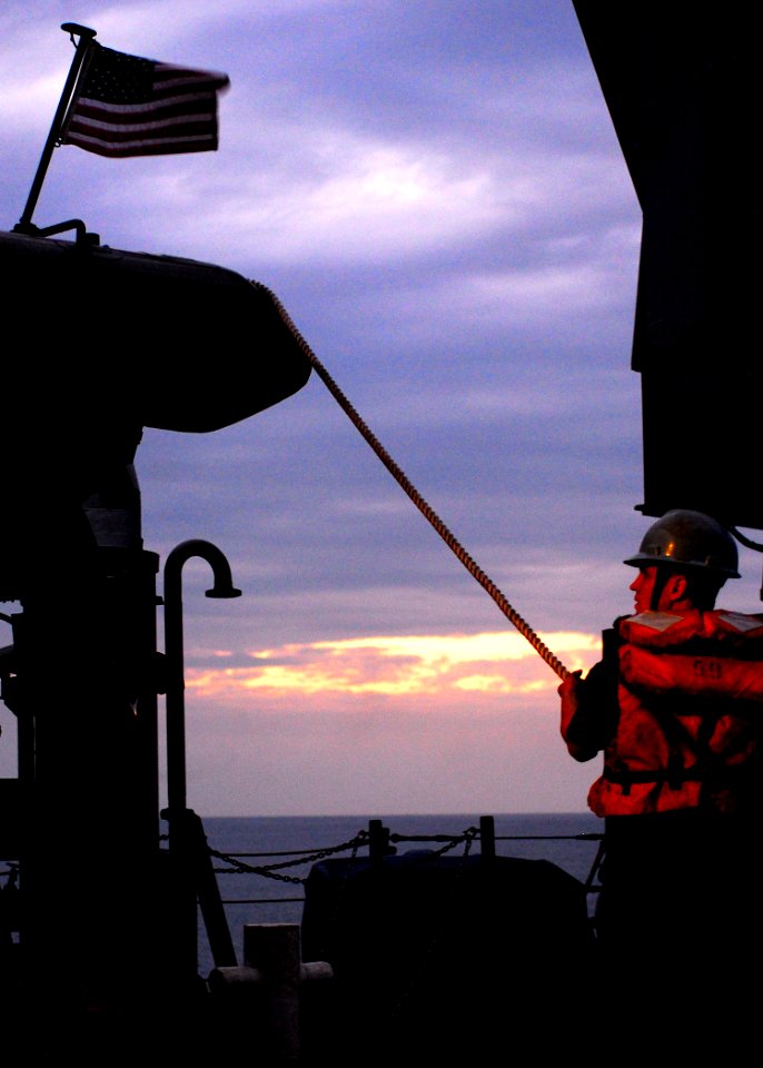 US Navy 100125-N-5244H-004 Seaman Jesse Willson steadies a rigid-hull inflatable boat as it is craned onto the deck of amphibious dock landing ship USS Carter Hall (LSD 50)