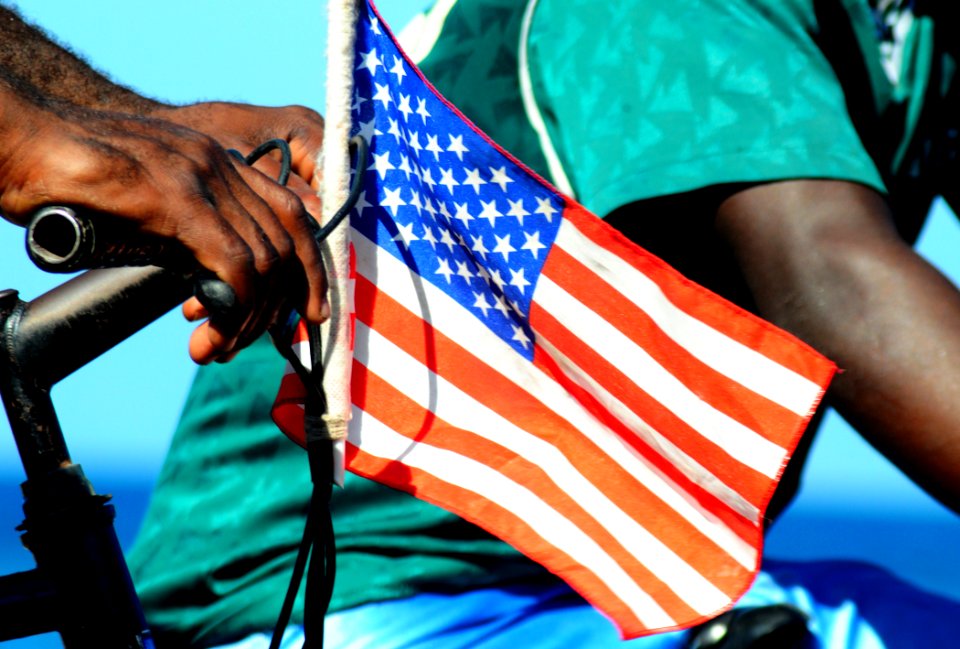 US Navy 100123-N-7508R-051 A Haitian citizen flies an American flag on his bicycle as a display of appreciation to U.S. service members supporting Operation Unified Response