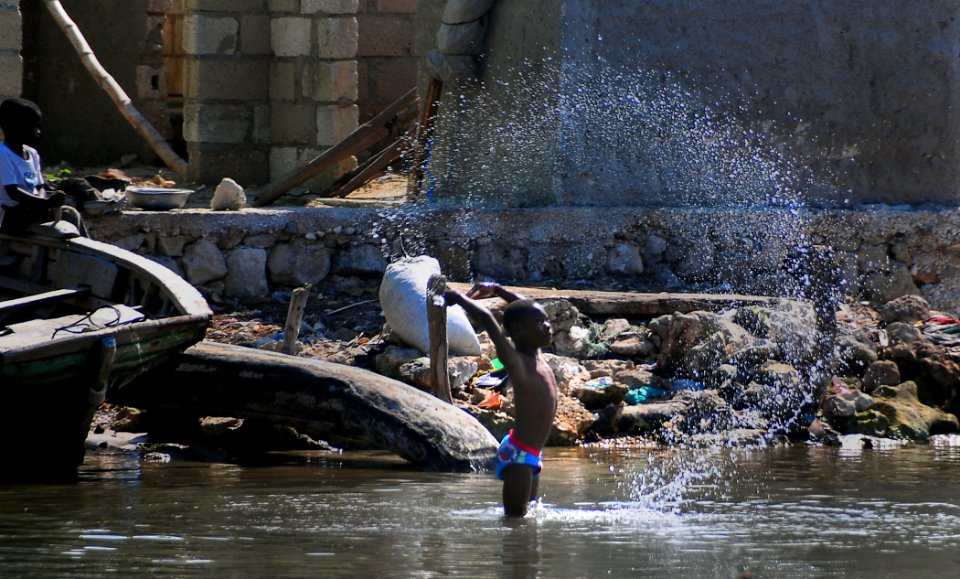 US Navy 100123-N-4774B-144 A Haitian boy plays in the bay while Sailors from the guided-missile cruiser USS Normandy (CG 60) perform an assessment of the area
