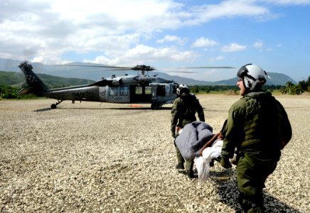 US Navy 100125-N-5345W-138 Air crewmen assigned to the Sea Knights of Helicopter Sea Combat Squadron (HSC) 22 prepare to load an injured Haitian man onto an MH-60S Sea Hawk helicopter photo