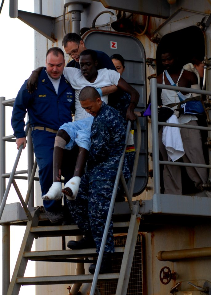 US Navy 100124-N-4971L-028 Sailors aboard USS Fort McHenry (LSD 43) carry injured Haitian medical evacuees to an MH-60S Sea Hawk helicopter