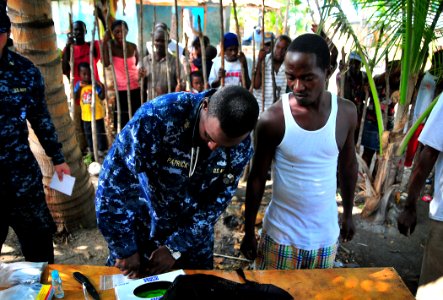US Navy 100125-N-4774B-174 Chief Hospital Corpsman Carletus Patrick, assigned to the guided-missile cruiser USS Bunker Hill (CG 52), prepares medicine for Haitian children