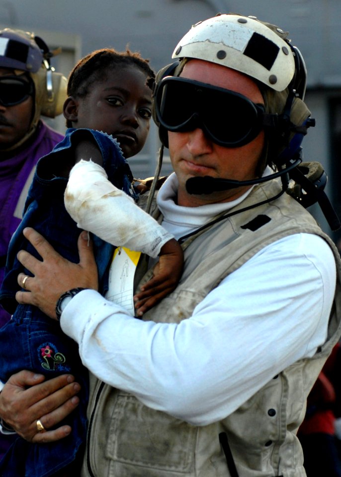 US Navy 100124-N-4971L-058 Lt.j.g. Jeffrey Dolan carries an injured Haitian girl to an MH-60S Sea Hawk helicopter