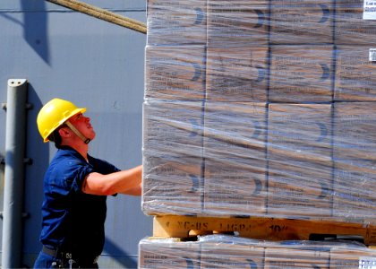 US Navy 100124-N-5244H-024 Boatswain's Mate Seaman Michael Westerfield prepares pallets of humanitarian aid rations to be craned onto the ship
