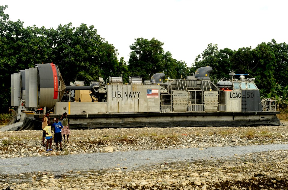 US Navy 100125-N-5345W-415 Local Haitian children stand in front of a landing craft air cushion