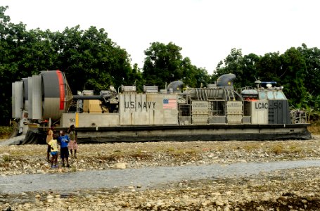 US Navy 100125-N-5345W-415 Local Haitian children stand in front of a landing craft air cushion