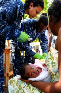 US Navy 100125-N-8878B-206 Culinary Specialist 1st Class Naqueline Shaw assists Chief Hospital Corpsman Carletus Patrick in treating patients