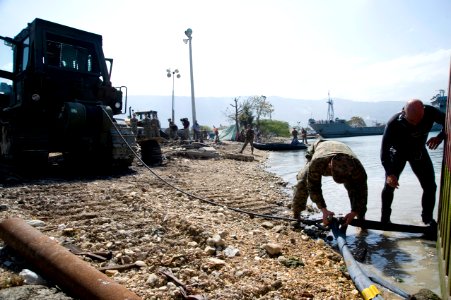 US Navy 100125-N-1134L-143 hief Warrant Officer 4 Jeff Barone works with a Marine to remove submerged container boxes
