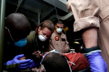 US Navy 100125-N-5712P-005 Sailors administer to medical evacuees from Haiti being treated aboard the amphibious assault ship USS Nassau (LHA 4) photo