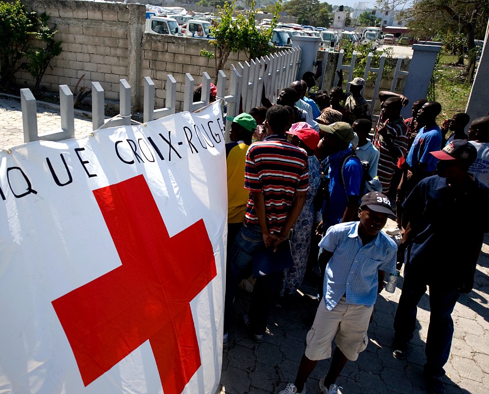 US Navy 100125-N-6266K-135 Haitian earthquake survivors wait to receive non-perishable goods from a local Red Cross distribution site in Port-au-Prince