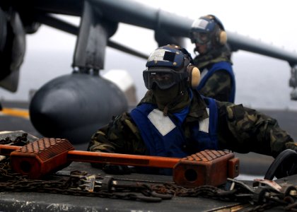 US Navy 100125-N-5215E-048 Aviation Boatswain's Mate Airman Michael Aranas backs up an aircraft tractor