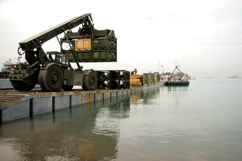 US Navy 100126-N-1134L-335 Marines assigned to 8th Engineer Support Battalion unload supplies from a floating causeway offloaded from the Military Sealift Command maritime prepositioning ship USNS 1st Lt. Jack Lummus (T-AK 3011
