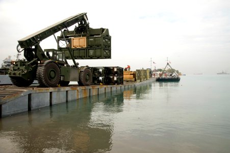 US Navy 100126-N-1134L-335 Marines assigned to 8th Engineer Support Battalion unload supplies from a floating causeway offloaded from the Military Sealift Command maritime prepositioning ship USNS 1st Lt. Jack Lummus (T-AK 3011