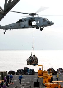 US Navy 100125-N-4971L-353 An MH-60S Sea Hawk Helicopter from Helicopter Sea Support Squadron (HSC) 2 delivers stores and relief supplies to the amphibious dock landing ship USS Fort McHenry (LSD 43)