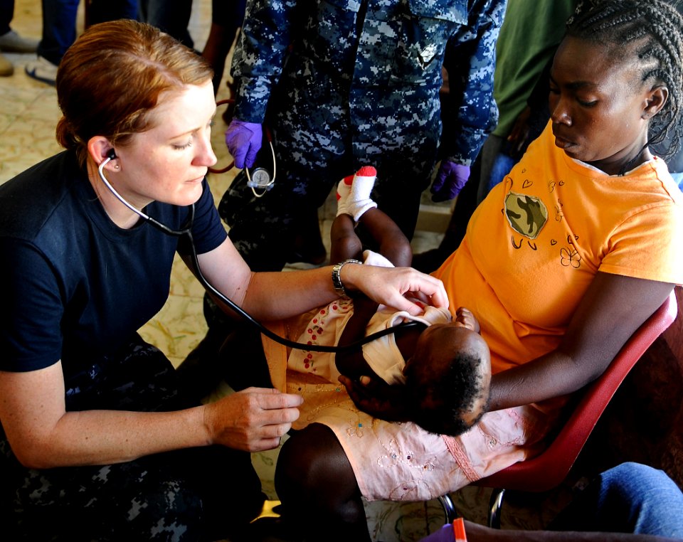 US Navy 100125-N-5345W-265 Lt. Adrienne Lawton xamines a Haitian infant at the Lifeline Christian Ministries Mission medical clinic in Grand Goave