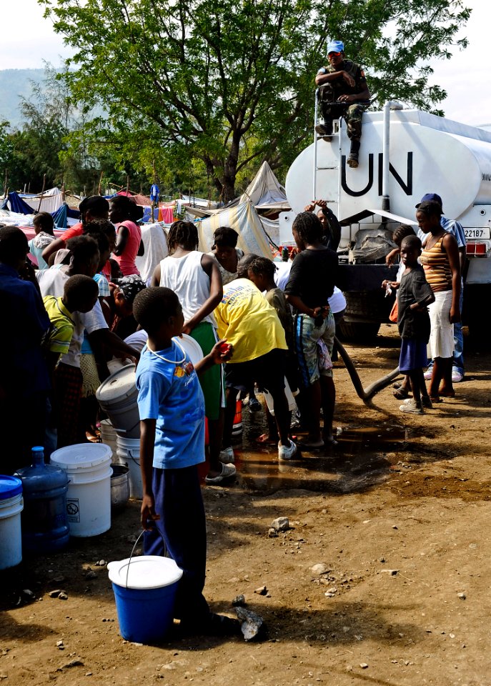US Navy 100125-N-5345W-199 A Sri Lanka Navy Sailor serving as a U.N. peacekeeper provides security from atop a U.N. water truck as dozens of displaced Haitians wait in line for fresh drinking water at the Lifeline Christian Min