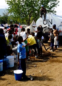 US Navy 100125-N-5345W-199 A Sri Lanka Navy Sailor serving as a U.N. peacekeeper provides security from atop a U.N. water truck as dozens of displaced Haitians wait in line for fresh drinking water at the Lifeline Christian Min