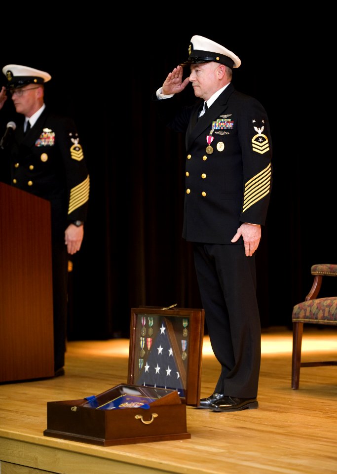 US Navy 100126-N-8053S-075 Master Chief Scott Weaver, right, command master chief, U.S.Naval Forces Central Command, salutes fellow chiefs at his retirement ceremony at Naval Support Activity Bahrain