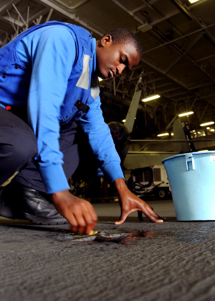 US Navy 100125-N-5685W-202 Aviation Boatswain's Mate (Handling) Airman Rayshawn Sharpe cleans hangar bay pad eyes aboard the Nimitz-class aircraft carrier USS Harry S. Truman (CVN 75)