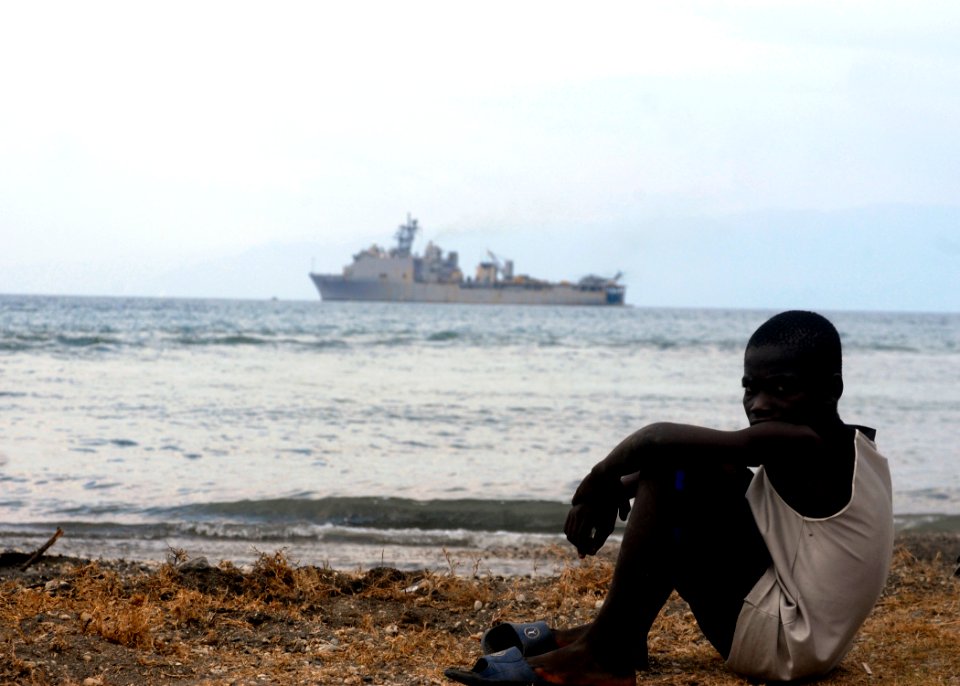 US Navy 100126-N-2000D-395 A Haitian boy sits near the beach landing zone as USS Carter Hall (LSD 50) conducts amphibious operations