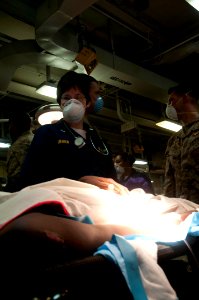 US Navy 100125-N-5712P-040 Lt. Jennifer Isner watches a recently stabilized medical evacuee from Haiti photo
