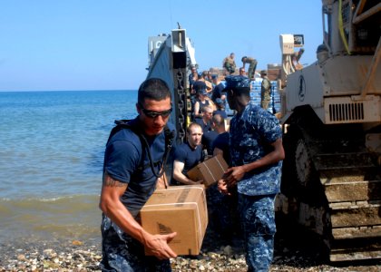 US Navy 100127-N-2000D-008 Sailors and Marines off-load food rations and water from a landing craft utility vehicle