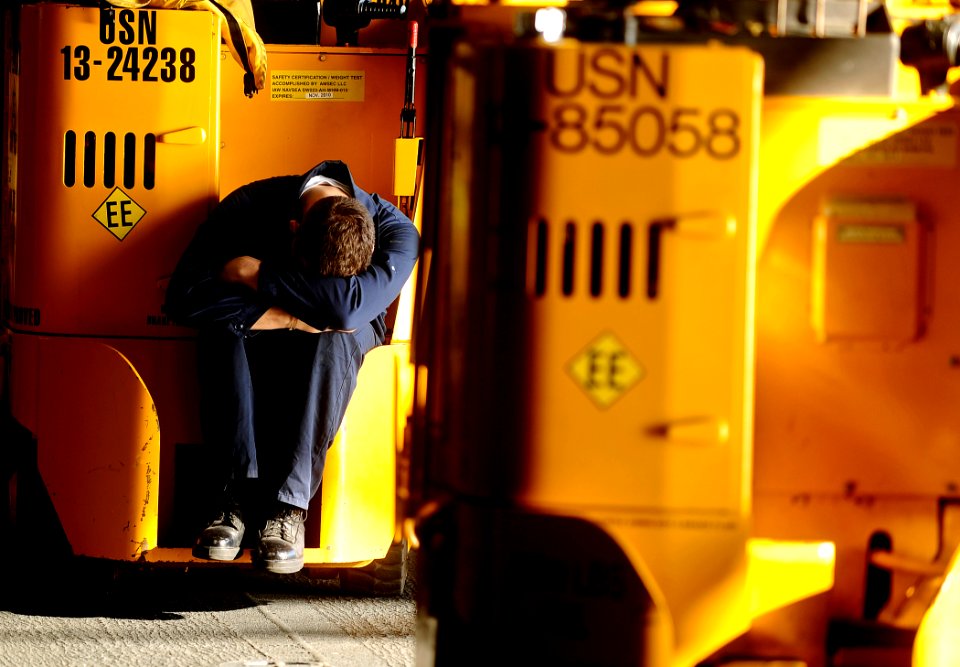 US Navy 100127-N-5345W-068 Aviation Boatswain's Mate Airman Kyle Cavins rests on the back of his forklift during a lull in humanitarian aid onloads as the multi-purpose amphibious assault ship USS Bataan (LHD 5)