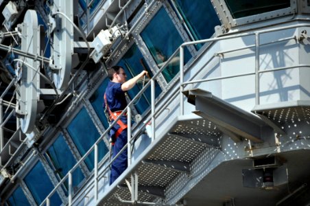 US Navy 100125-N-8421M-024 Quartermaster 2nd Class Cameron Fletcher cleans the flag bridge windows aboard the aircraft carrier USS Nimitz (CVN 68)