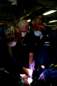 US Navy 100125-N-5712P-018 Sailors administer to medical evacuees from Haiti being treated aboard the amphibious assault ship USS Nassau (LHA 4) photo
