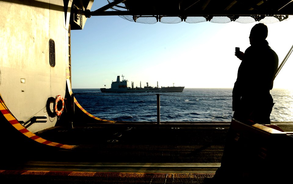 US Navy 100127-N-5345W-169 A Sailor snaps a photo on his cell phone from the hangar bay of the multi-purpose amphibious assault ship USS Bataan (LHD 5)