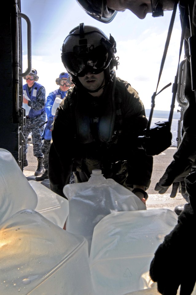 US Navy 100125-N-8878B-048 Sailors from load a helicopter with water to be distributed to affected areas of Haiti