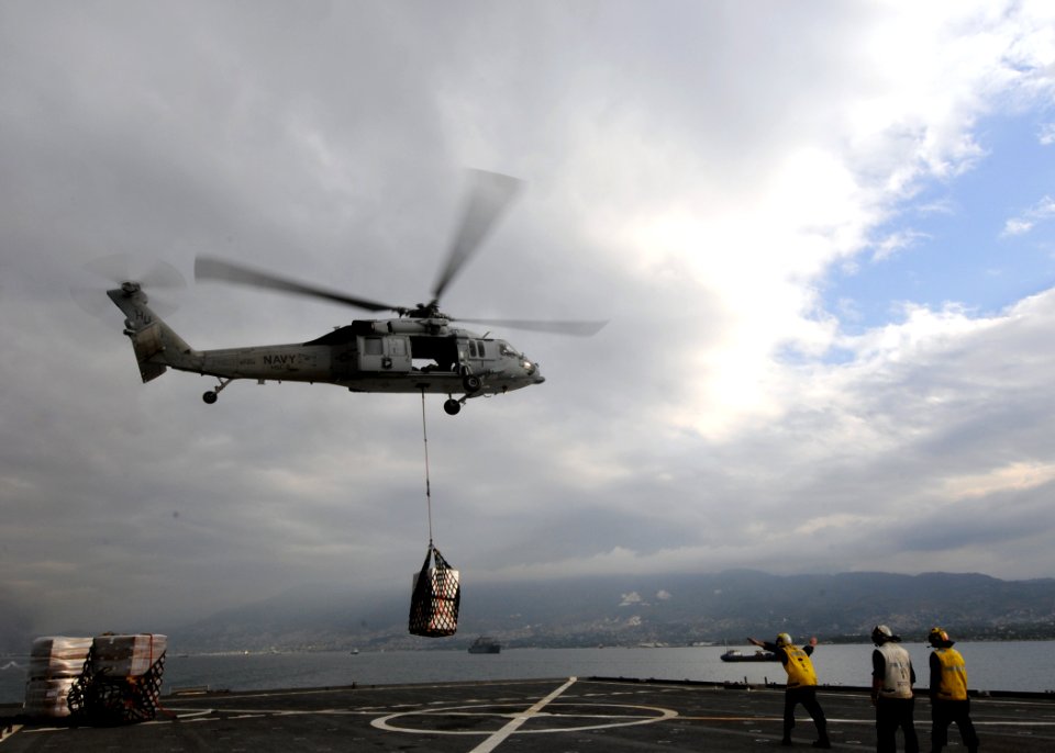 US Navy 100126-N-6676S-230 An MH-60S Sea Hawk helicopter assigned to Helicopter Sea Support Squadron (HSC) 2 delivers stores and relief supplies to the amphibious dock landing ship USS Gunston Hall (LSD 44)