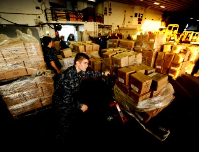 US Navy 100127-N-5345W-235 Logistics Specialist Seaman Tyler Stringer prepares to move a load of humanitarian aid across the hangar bay of the multi-purpose amphibious assault ship USS Bataan (LHD 5)