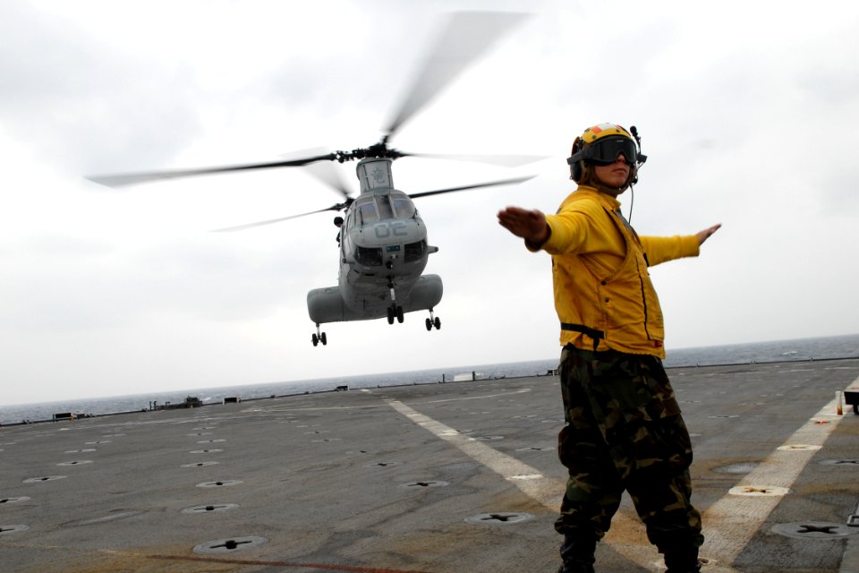 US Navy 100126-N-6692A-024 Boatswains Mate 3rd Class Kyle Eggering signals a Marine Corps CH-46 Sea Knight helicopter to launch