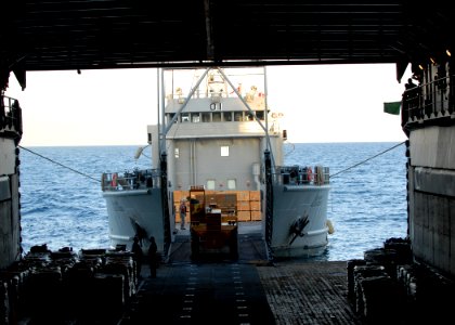 US Navy 100128-N-2000D-317 ailors aboard the amphibious dock landing ship USS Carter Hall (LSD 50) transfer pallets of food rations from Carter Hall to U.S. Army Landing Craft Unit 2001