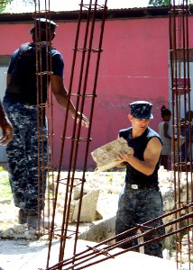 US Navy 100127-N-0924R-007 Navy Chaplain Lt. Devon Foster and Gunner's Mate 3rd Class Nicholas Bartlett remove rubble from a home in Neply during a community relations project