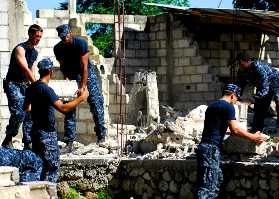 US Navy 100127-N-5244H-053 Sailors assigned to the amphibious dock landing ship USS Carter Hall (LSD 50) remove rubble from a home during a community relations (COMREL) project