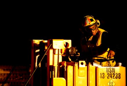 US Navy 100127-N-5345W-197 Aviation Boatswain's Mate 1st Class Enrique Gerald waits with his forklift in the hangar bay of the multi-purpose amphibious assault ship USS Bataan (LHD 5)