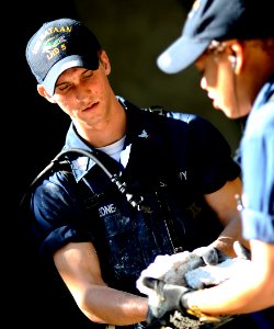 US Navy 100129-N-5345W-074 Gunner's Mate 3rd Class Peter Sansone, assigned to the multi-purpose amphibious assault ship USS Bataan (LHD 5), clears rubble from an outdoor classroom