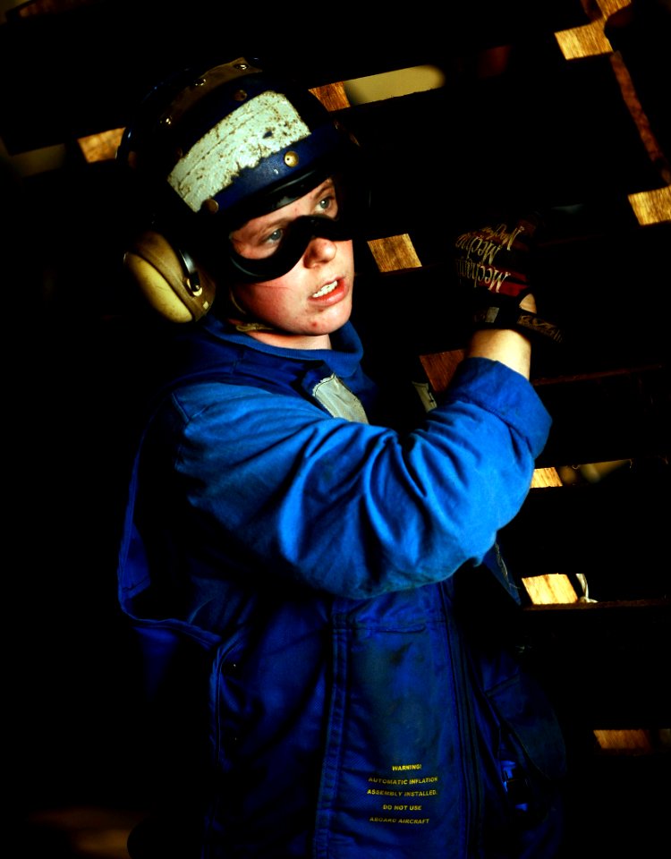 US Navy 100127-N-5345W-211 Aviation Boatswain's Mate 3rd Class Leila Pursell carries a pallet across the hangar bay of the multi-purpose amphibious assault ship USS Bataan (LHD 5)