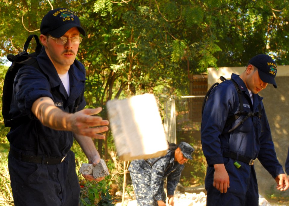 US Navy 100129-N-1092P-050 Machinist Mate Fireman Chris Strickland helps clear rubble from fallen buildings in Grand-Goave, Haiti