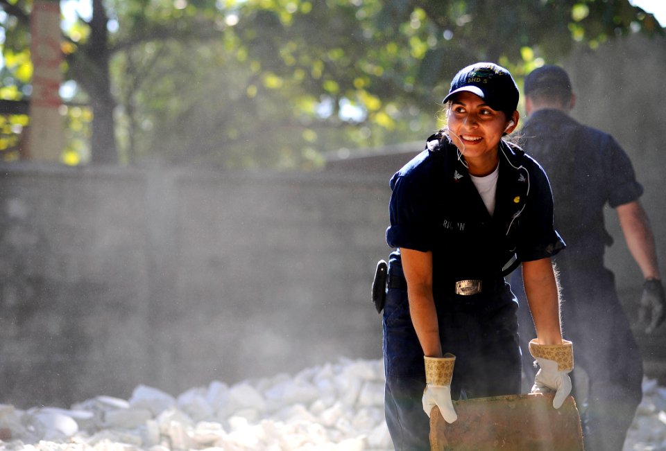 US Navy 100129-N-5345W-048 Boatswain's Mate 3rd Class Isabel Pericon, assigned to the multi-purpose amphibious assault ship USS Bataan (LHD 5), clears rubble and debris from an outdoor classroom