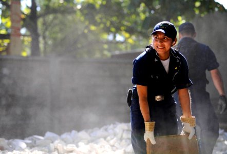 US Navy 100129-N-5345W-048 Boatswain's Mate 3rd Class Isabel Pericon, assigned to the multi-purpose amphibious assault ship USS Bataan (LHD 5), clears rubble and debris from an outdoor classroom