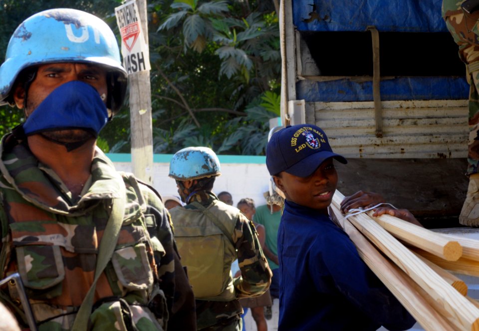 US Navy 100128-N-1831S-047 Boatswain's Mate 2nd Class Shaquita Smith takes lumber from the back of a U.N. truck to drop off at the Operation Hope for Children of Haiti clinic in Killick
