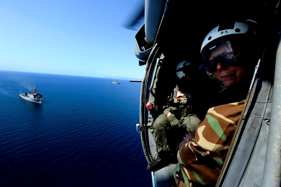 US Navy 100128-N-5345W-069 Rear Adm. Patricia Wolfe looks out from an MH-60S Sea Hawk helicopter as USS Gunston Hall (LSD 44) and USS Bataan (LHD 5) operate below off the coast of Haiti