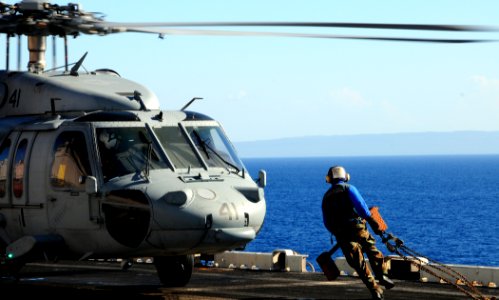 US Navy 100127-N-7508R-177 A Sailor carries a chock and chain to secure an MH-60S Sea Hawk helicopter assigned to Helicopter Sea Combat squadron (HSC) 22
